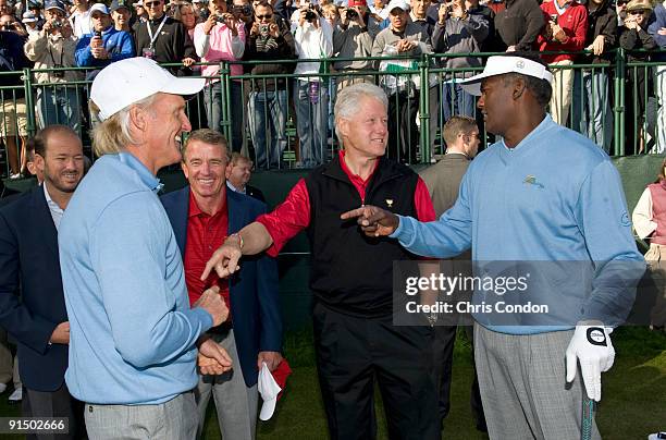 Former U.S. President Bill Clinton talks with International team Captain Greg Norman and Vijay Singh of Fiji on the driving range before practice for...