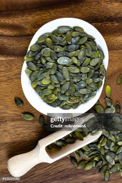directly above view of scoop on pumpkin seeds. - magnesium stock pictures, royalty-free photos & images