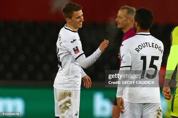 Swansea City's English midfielder Tom Carroll celebrates with Swansea City's English midfielder Wayne Routledge after scoring their seventh goal...