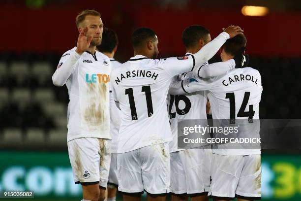 Swansea City's English midfielder Tom Carroll celebrates with teammates after scoring their seventh goal during the English FA Cup fourth round...