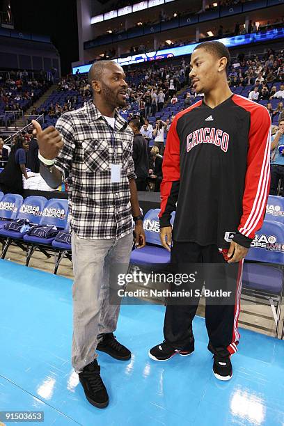 Derrick Rose of the Chicago Bulls speaks with Sunderland football player Darren Bent before a game between the Chicago Bulls and Utah Jazz during the...