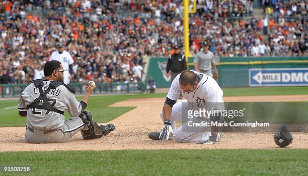 Ramon Castro of the Chicago White Sox holds up the baseball after tagging out Gerald Laird of the Detroit Tigers on a collision at home plate during...