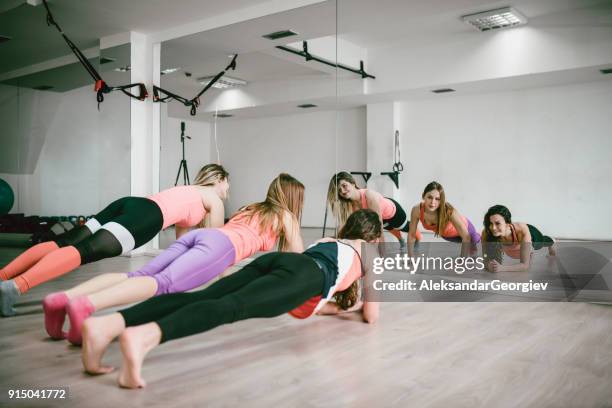 grupo de meninas fazer prancha posição abs exercício no ginásio a sorrir - ginástica de solo - fotografias e filmes do acervo