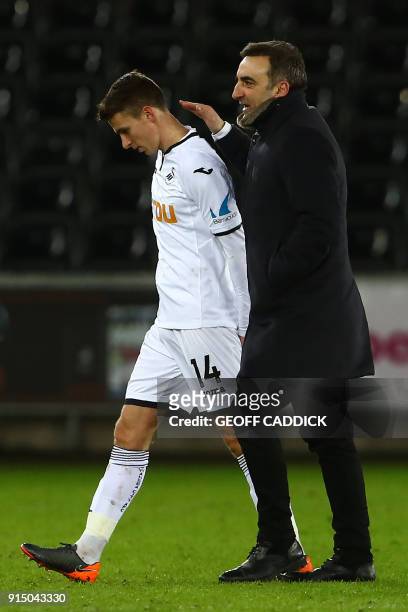 Swansea City's Portuguese manager Carlos Carvalhal walks off with Swansea City's English midfielder Tom Carroll after the English FA Cup fourth round...