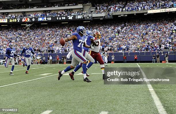 Osi Umenyiora of the New York Giants runs with the ball towards the goal line after recovering a fumble against the Washington Redskins during their...