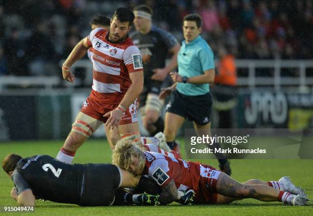 Richard Hibbard and Gareth Evens of Gloucester Rugby tackle Kyle Cooper of Newcastle Falcons during the Anglo-Welsh Cup match between Newcastle...