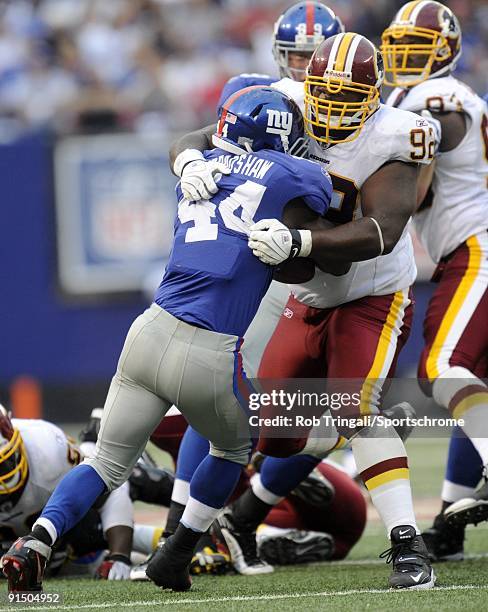 Albert Haynesworth of the Washington Redskins tackles Ahmad Bradshaw of the New York Giants during their game on September 13, 2009 at Giants Stadium...