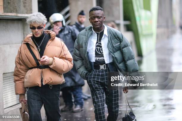 Guest wears a puffer coat, under the rain, outside Paul Smith, during Paris Fashion Week - Menswear Fall Winter 2018-2019, on January 21, 2018 in...