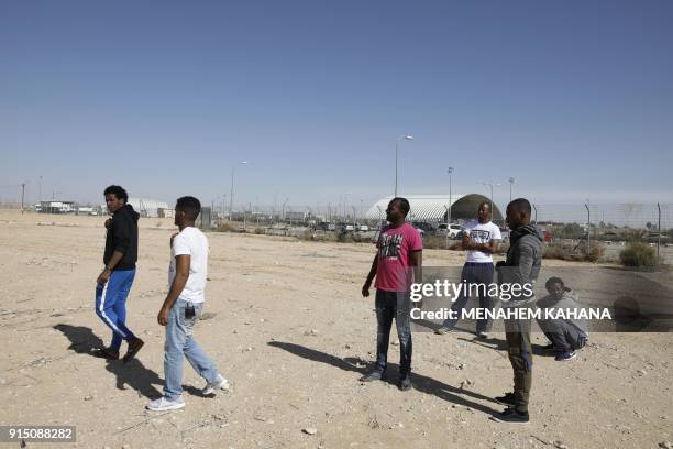 Picture taken on February 4, 2018 shows detained African migrants standing outside the Holot detention centre, located in Israel's southern Negev...