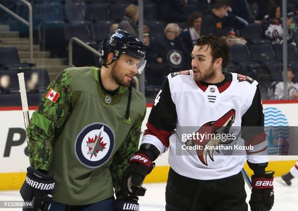 Ben Chiarot of the Winnipeg Jets and Zac Rinaldo of the Arizona Coyotes chat during the pre-game warm up prior to NHL action at the Bell MTS Place on...
