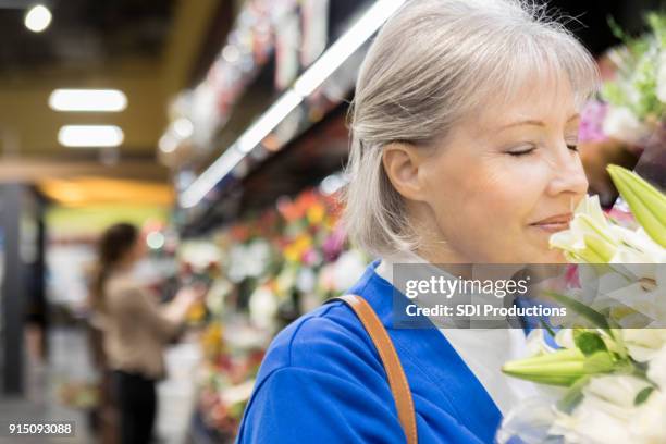 senior vrouw winkelen voor bloemen - coronaal doorsnede stockfoto's en -beelden