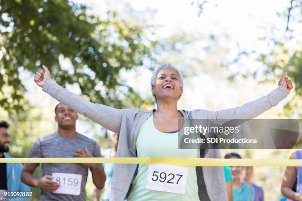 senior woman wins a charity race - marathon-race-winner stock pictures, royalty-free photos & images