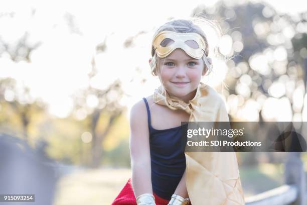 pretty elementary age girl wearing cape and mask - superhero girl stock pictures, royalty-free photos & images