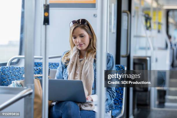 mujer trabaja en la computadora portátil mientras viajaba en tren de cercanías - bus interior fotografías e imágenes de stock