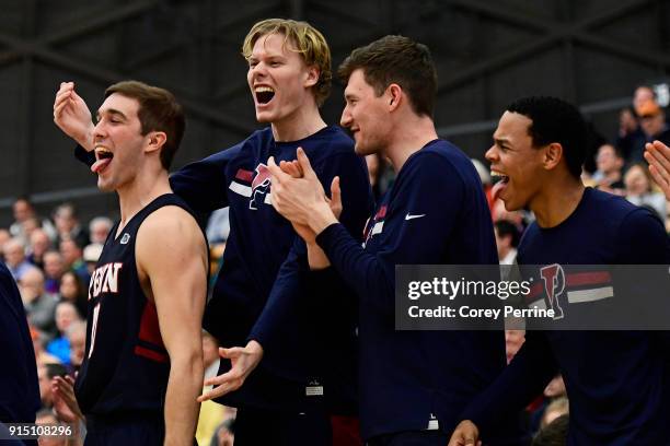 Matt MacDonald, Sam Jones, Collin McManus and Ray Jerome of the Pennsylvania Quakers react to a score on the bench against the Princeton Tigers...