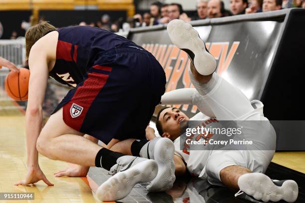 Devin Cannady of the Princeton Tigers tumbles over Caleb Wood of the Pennsylvania Quakers during the first half at L. Stockwell Jadwin Gymnasium on...