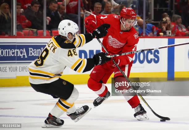 Dylan Larkin of the Detroit Red Wings makes a move around Matt Grzelcyk of the Boston Bruins during the second period at Little Caesars Arena on...