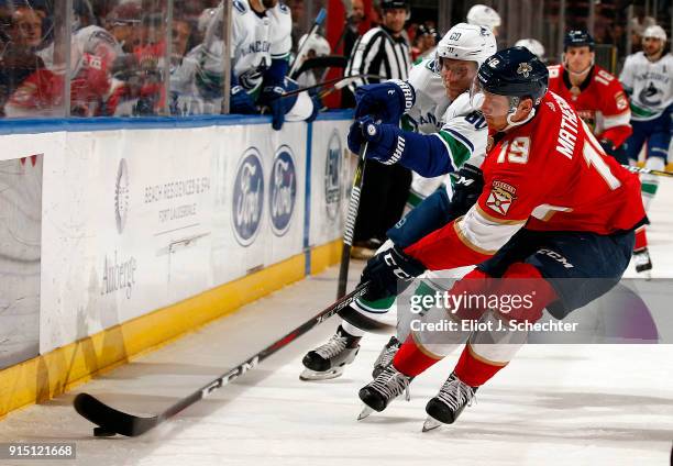Michael Matheson of the Florida Panthers digs the puck out from the boards against Markus Granlund of the Vancouver Canucks at the BB&T Center on...