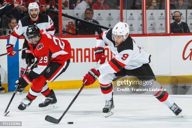 Taylor Hall of the New Jersey Devils skates with the puck against Johnny Oduya of the Ottawa Senators at Canadian Tire Centre on February 7, 2018 in...