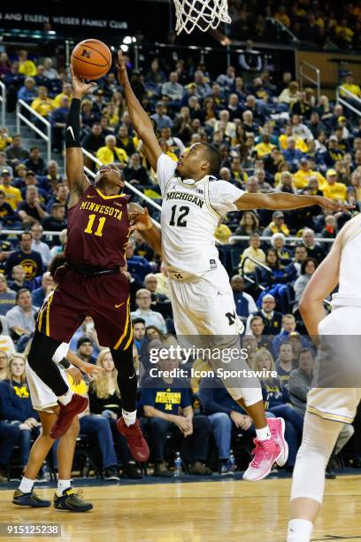 Minnesota Golden Gophers guard Isaiah Washington goes in for a layup against Michigan Wolverines guard Muhammad-Ali Abdur-Rahkman during a regular...