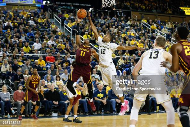 Minnesota Golden Gophers guard Isaiah Washington goes in for a layup against Michigan Wolverines guard Muhammad-Ali Abdur-Rahkman during a regular...