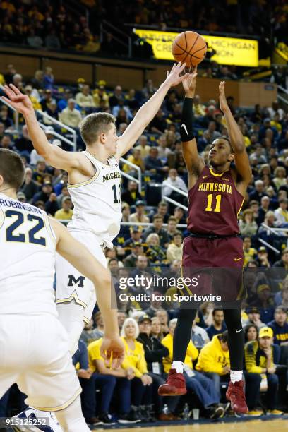 Minnesota Golden Gophers guard Isaiah Washington shoots over Michigan Wolverines forward Moritz Wagner during a regular season Big 10 Conference...