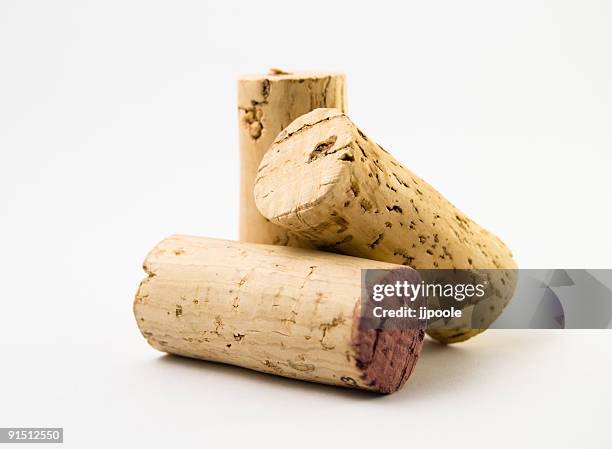 three wine corks on white background - kurk drankenbenodigdheden stockfoto's en -beelden