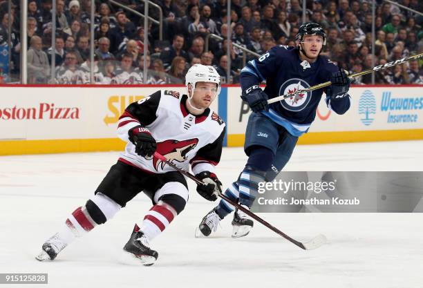 Max Domi of the Arizona Coyotes and Marko Dano of the Winnipeg Jets keep an eye on the play during first period action at the Bell MTS Place on...