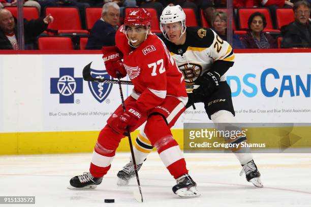 Andreas Athanasiou of the Detroit Red Wings tries to control the puck in front of Riley Nash of the Boston Bruins during the third period at Little...