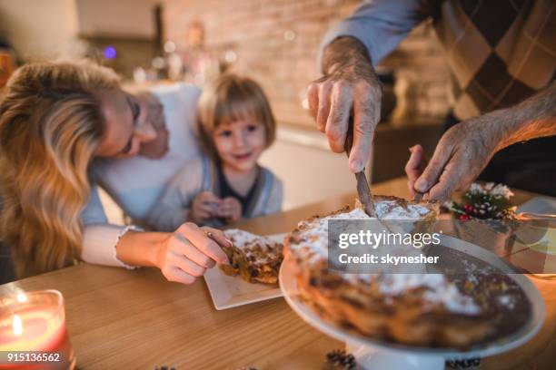 close up of unrecognizable man cutting apple pie during meal with his family. - man eating pie stock pictures, royalty-free photos & images