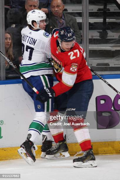 Nick Bjugstad of the Florida Panthers and Ben Hutton of the Vancouver Canucks come together along the boards during third-period action at the BB&T...
