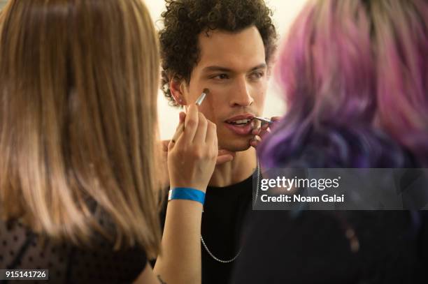 Model prepares backstage at the Perry Ellis fashion show during New York Fashion Week Mens' at The Hippodrome Building on February 6, 2018 in New...