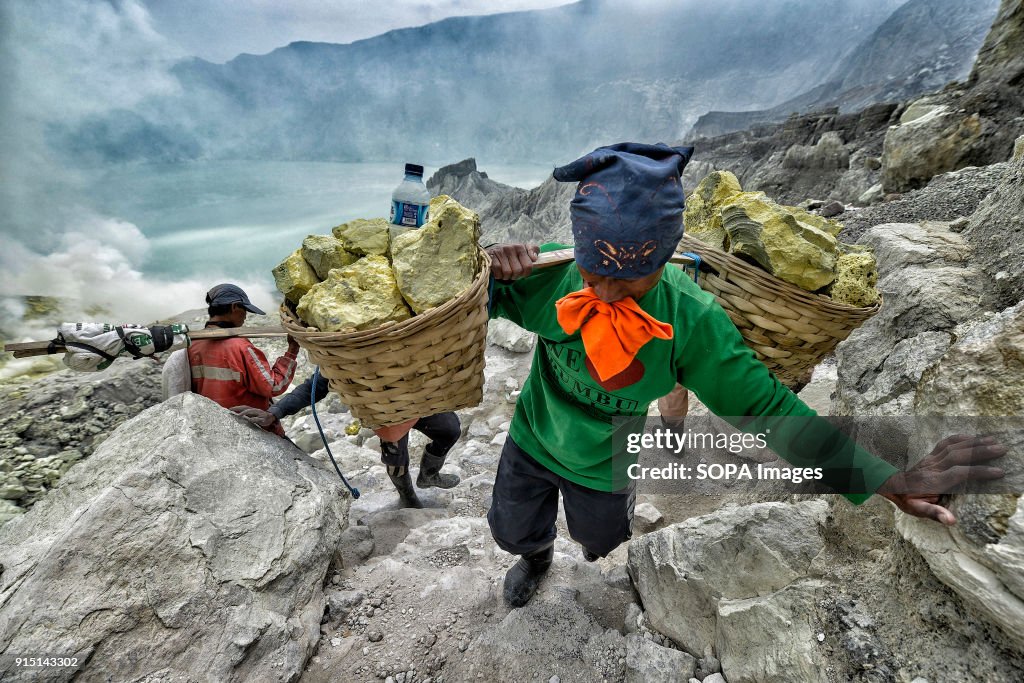 A miner climbing from the bottom of the crater loaded with...