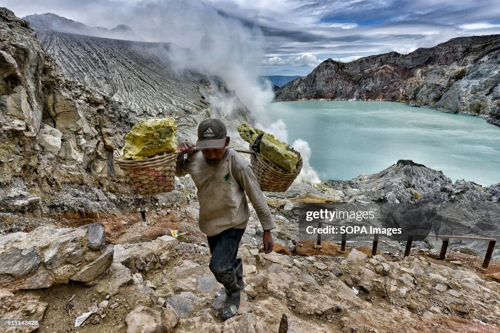 A miner climbing from the bottom of the crater loaded with...