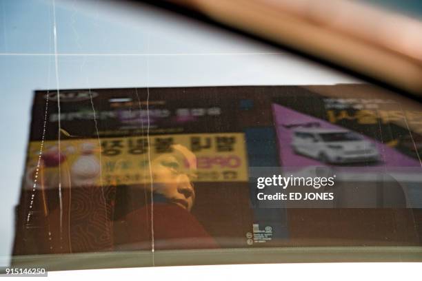 North Korean cheerleader looks from the window of a bus convoy carrying a 280-member delegation on its way to the 2018 Pyeongchang winter Olympic...