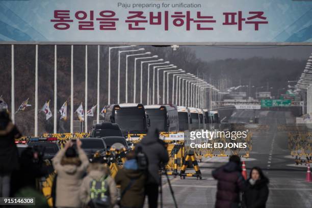 Busses carrying a 280-member delegation of North Korean cheerleaders heading for the 2018 Pyeongchang winter Olympic games, crosses a checkpoint on...