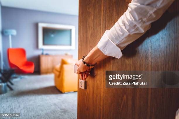hand van de man de deur van de luxe hotelkamer - closing door stockfoto's en -beelden