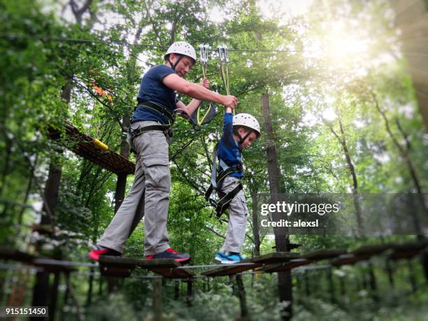 hochseilgarten klettern hindernis abenteuer teamarbeit - hindernisparcours stock-fotos und bilder