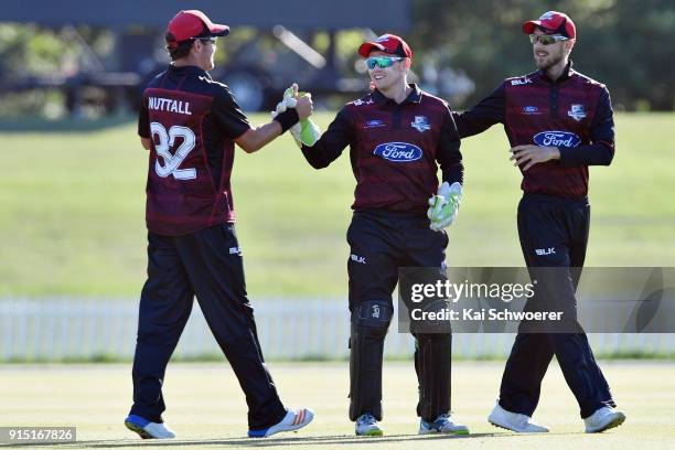 Tom Latham of Canterbury is congratulated by team mates after taking a catch to dismiss Lockie Ferguson of the Auckland Aces during the One Day Ford...