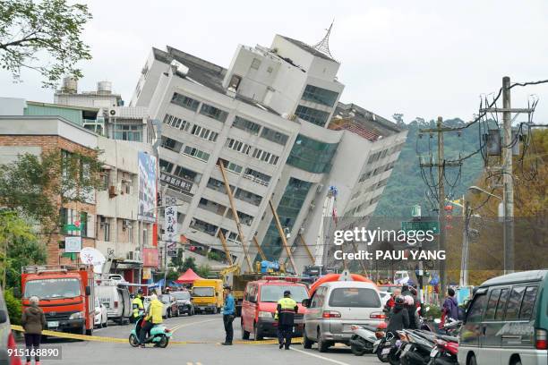 Rescue and emergency workers block off a street where a building came off its foundation, the morning after a 6.4 magnitude quake hit the eastern...