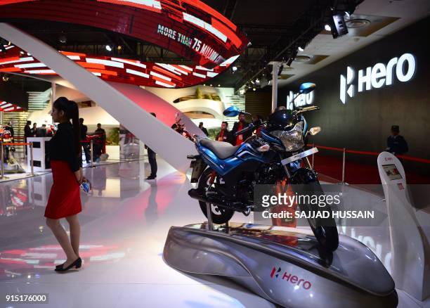 Model stands near Hero Moto Corp's Passion Xpro motorcycle during the Indian Auto Expo 2018 in Greater Noida on February 7, 2018. / AFP PHOTO /...