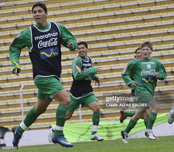 Bolivian national footballers Diego Cabrera, Jose Luis Chavez and Alejandro Chumacero run during a training session in the Hernando Siles stadium in...