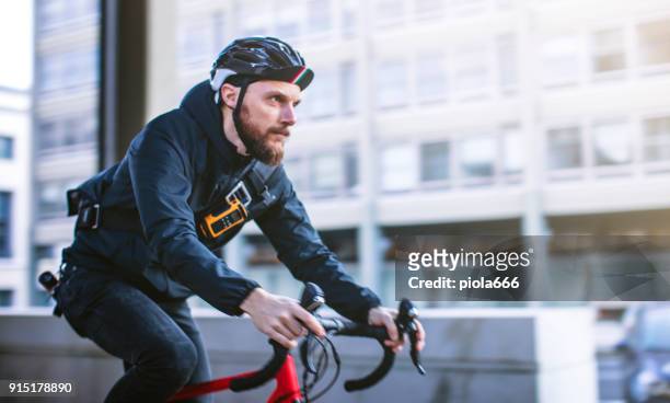 fahrradkurier: pendler mit rennrad in der stadt - bike messenger stock-fotos und bilder