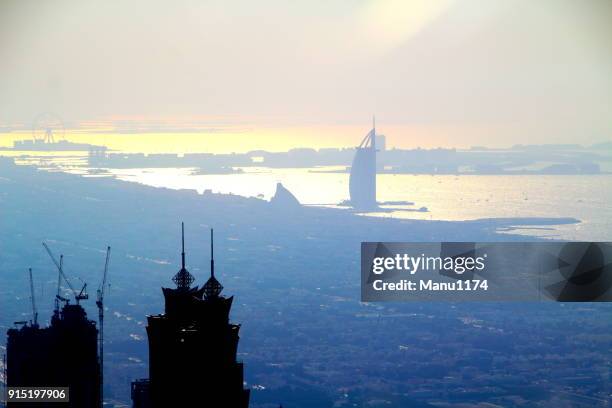 dubai skyline uitzicht op burj al arab hotel boven de horizon. - burj al arab night stockfoto's en -beelden