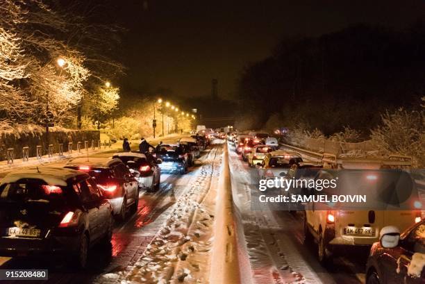 Stranded vehicles stand on the blocked D444 road near Bievres, southwest of Paris, early February 7 after heavy overnight snowfall in northern...