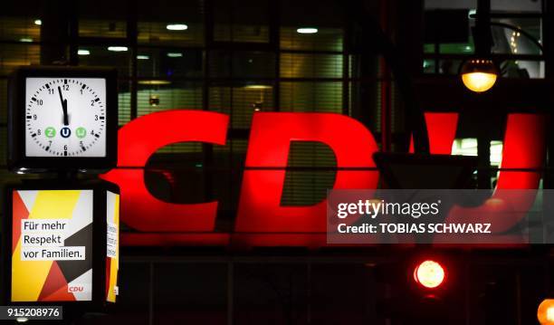 Clock displays almost midnight and a CDU slogan reads "for more respect for families" in front of the Christian Democrats headquarters on February 6,...