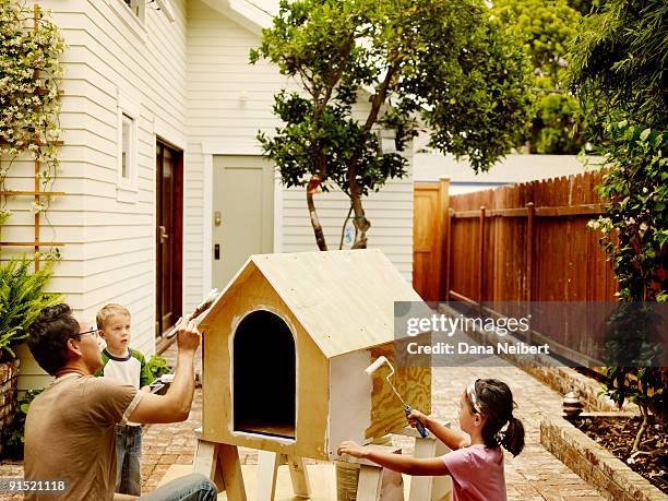 father and children work on dog house. - kennel stock pictures, royalty-free photos & images