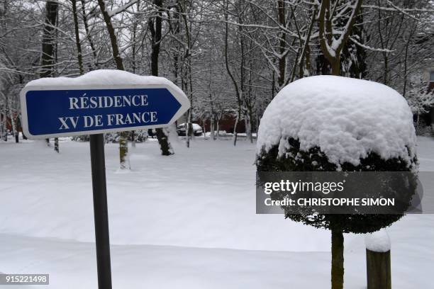 Snow sits on a sign for the French National Rugby Union Team Headquarters at Marcoussis on February 7 after the training session for the players...