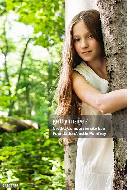 girl with long hair hugging a tree - girl tree foto e immagini stock