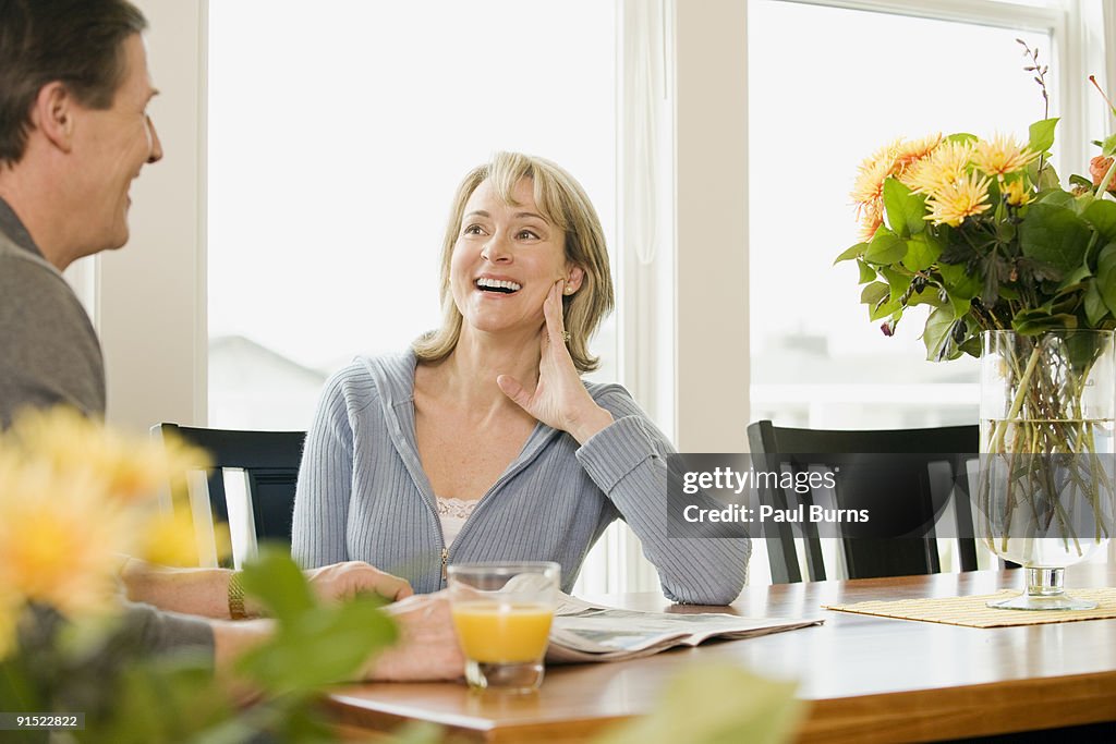 Happy Couple Laughing and sitting in dining table